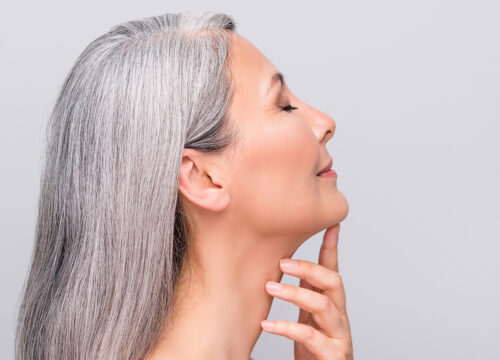 Photo of an older woman touching the skin under her chin